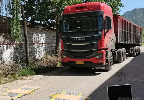 Caminhão de carga posicionado sobre as sapatas de pesagem na via
